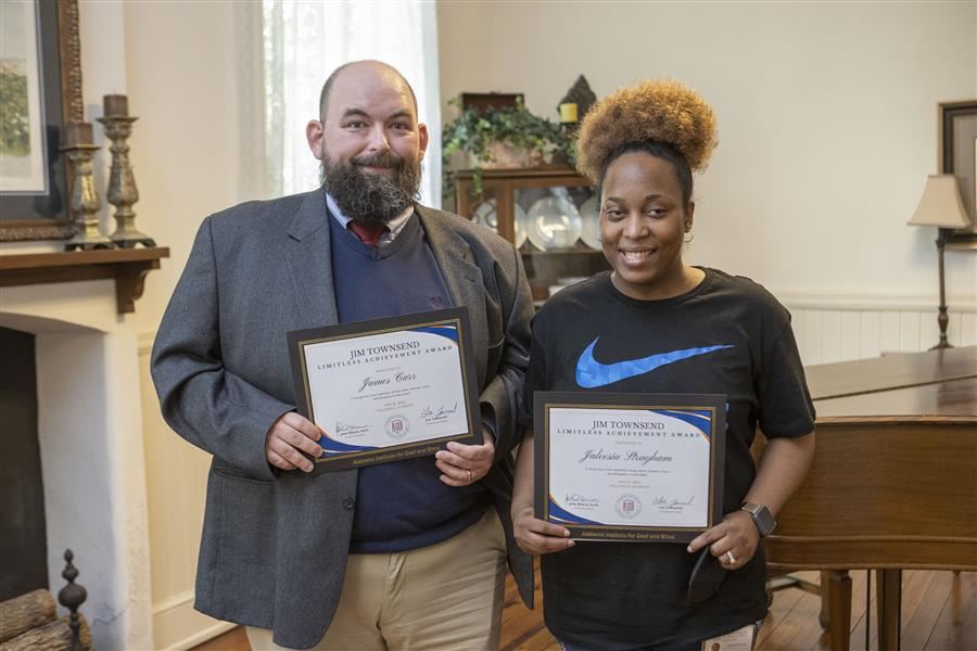 James Carr and Jaleesia Straham smile to the camera each holding their certificate.